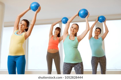 pregnancy, sport, fitness and healthy lifestyle concept - group of happy pregnant women training with small exercise balls in gym - Powered by Shutterstock