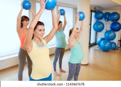 pregnancy, sport, fitness and healthy lifestyle concept - group of happy pregnant women training with small exercise balls in gym
