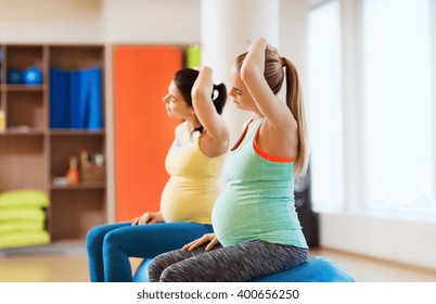 pregnancy, sport, fitness, people and healthy lifestyle concept - group of happy pregnant women exercising on ball in gym - Powered by Shutterstock