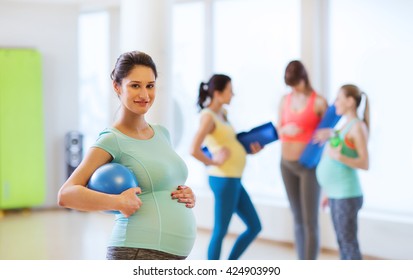 Pregnancy, Sport, Fitness, People And Healthy Lifestyle Concept - Happy Pregnant Woman With Ball In Gym