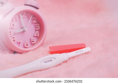 Pregnancy test device to determine a pregnant woman. Health and medicine concept with clock on the back.          