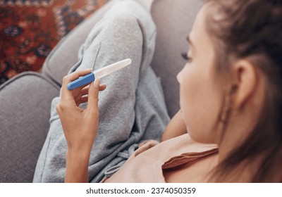 Pregnancy test, waiting and woman on sofa in home, reading news and check results.,Stick, sad and pregnant mother in living room for future maternity, ivf fertility and anxiety, depressed or serious