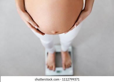 Pregnancy Weight Control. Pregnant Woman On Scale