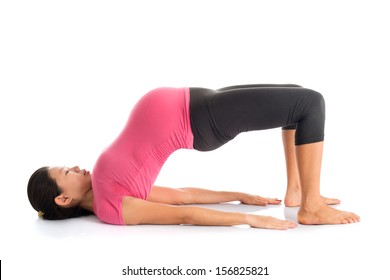 Pregnancy yoga class. Full length healthy Asian pregnant woman doing yoga exercise stretching, full body isolated on white background. Yoga bridge pose.