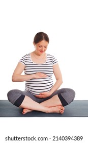 Pregnancy yoga exercise - pregnant woman doing asana Sukhasana easy yoga pose embracing her belly isolated on white background