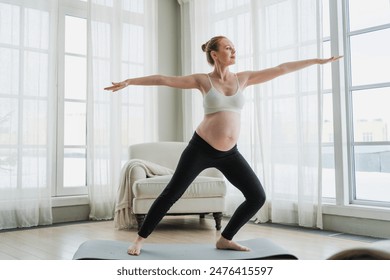 Pregnancy yoga fitness workout training. Pregnant woman practicing yoga at home. Pregnant girl doing sports exercise on yoga mat indoor. Woman with big belly have fitness training practicing asana - Powered by Shutterstock