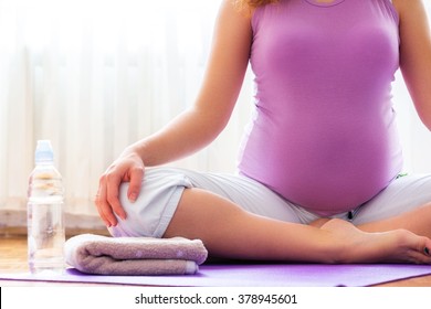 Pregnancy yoga. Young pregnant woman doing yoga at home.