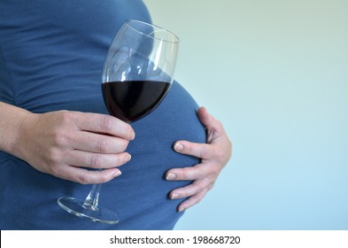 Pregnant adult woman want to drink alcohol craving red wine drink during pregnancy. Concept photo of alcoholic pregnant woman lifestyle medical health care. Real people. Copy Space