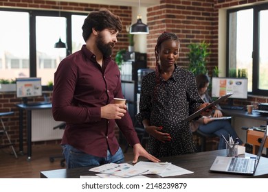 Pregnant African American Businesswoman Having Clipboard Looking Over Financial Data. Company Coworkers Reviewing Start Up Project Marketing Ideas And Business Strategy While In Agency Office.