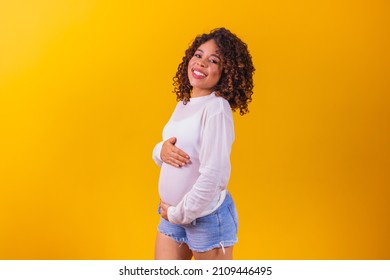 pregnant afro woman on yellow background