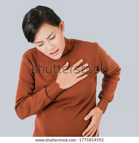 Pregnant  asia women Use the hand to grasp her chest and feel pain in the chest area.Focus on face