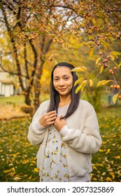 Pregnant Asian Woman Enjoying Fall Colors, Falling Leaves Natural Background