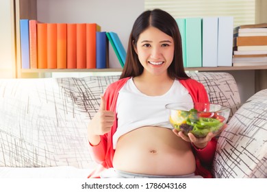 Pregnant Asian Woman Holding Salad Bowl, Give Thump Up With Smile Face. Vegetable Is Healthy Food For Pregnancy Mother. Mom Care And Concern Her Baby Or Fetus. Prenatal, Pregnancy, Motherhood Concept