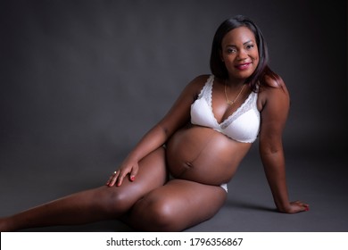 Pregnant black girl in white underwear with black background
