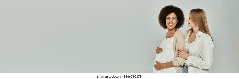 A pregnant Black woman and her partner, a White woman, stand together and look towards the future, hands on their bellies. - Powered by Shutterstock