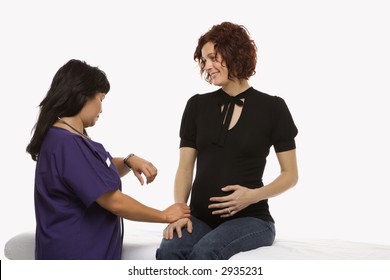 Pregnant Caucasian Mid-adult Woman Having Vital Signs Checked By Nurse.