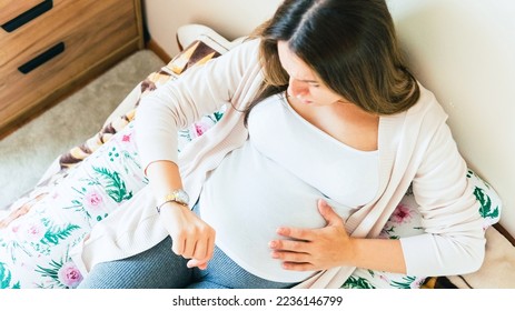 Pregnant clock time childbirth. Childbirth time, contractions pain. Pregnancy woman watching clock, holding baby belly. Pregnancy, medicine health care concept - Shutterstock ID 2236146799