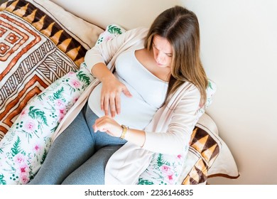 Pregnant clock time childbirth. Childbirth time, contractions pain. Pregnancy woman watching clock, holding baby belly. Pregnancy, medicine health care concept - Shutterstock ID 2236146835