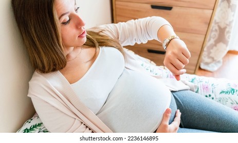 Pregnant clock time childbirth. Childbirth time, contractions pain. Pregnancy woman watching clock, holding baby belly. Pregnancy, medicine health care concept - Shutterstock ID 2236146895