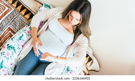 Pregnant contractions time. Pregnancy woman watching clock, holding baby belly. Childbirth time, contractions pain. Concept of pregnant, maternity, expectation for baby birth - Shutterstock ID 2236146903