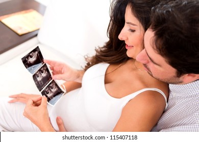 Pregnant couple looking at an ultrasound at home