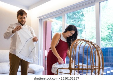 Pregnant couple preparing crib for future baby at home - Powered by Shutterstock