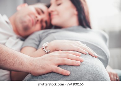 Pregnant couple relaxing at home and enjoying pregnancy time - Powered by Shutterstock