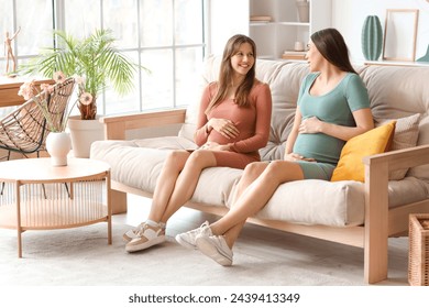 Pregnant female friends chatting on sofa at home - Powered by Shutterstock