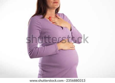 A pregnant girl who has heartburn in her stomach. Reflux of hydrochloric acid into the esophagus. Heartburn in pregnancy.