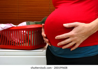 Pregnant Housewife Woman Doing Housework, Washing Family Clothes, During Pregnancy.Concept Photo Of Pregnancy, Pregnant Woman Lifestyle And Health Care. Crop Image - Copyspace