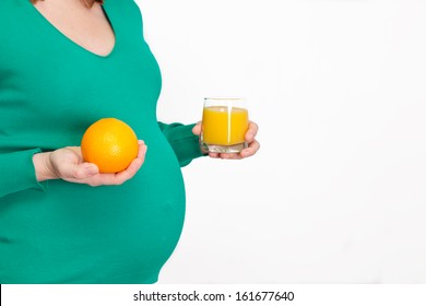 Pregnant lady holding orange juice in hand, healthy nutrition during pregnancy - Powered by Shutterstock