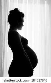 Pregnant lady silhouette near the window