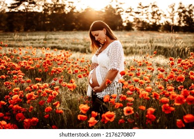 A pregnant model posing for a photoshoot in a field 