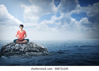 Pregnant mother doing yoga on the sea with blue sky background