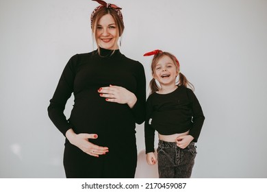 Pregnant Mother With Her Preschool Daughter Having Fun In Matching Outfits 