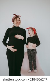 Pregnant Mother With Her Preschool Daughter Having Fun In Matching Outfits 