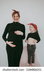 Pregnant Mother With Her Preschool Daughter Having Fun In Matching Outfits 