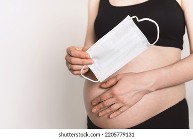 Pregnant Mother Use Face Mask Covering On Her Abdomen. Childbirth, Contractions With Face Mask During Quarantine. Afraid Spread Coronavirus Covid.