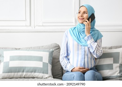 Pregnant Muslim Woman Talking By Mobile Phone At Home