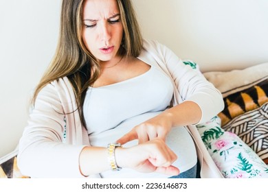 Pregnant pain contractions. Pregnant woman watching clock, holding baby belly. Childbirth time, contractions pain. Pregnancy, medicine health care concept - Shutterstock ID 2236146873