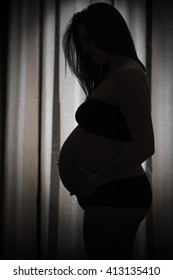 Pregnant woman against the light