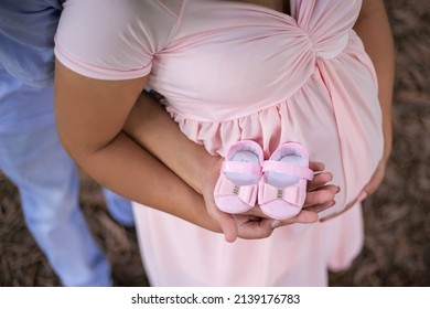 pregnant woman with baby shoes