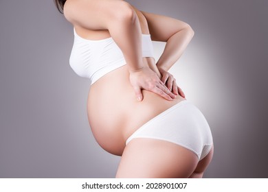 Pregnant Woman With Back Pain, Labor Pains, Risk Of Premature Birth, Gray Background