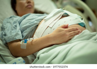 A pregnant woman being induced in the hospital, with iv and contractions monitor. - Shutterstock ID 1977552374