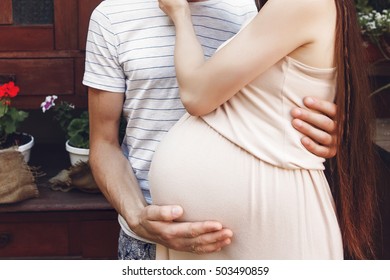 pregnant woman with big belly bump hugging with her husband. happy family waiting for baby. tender moments of parenthood. pregnancy concept