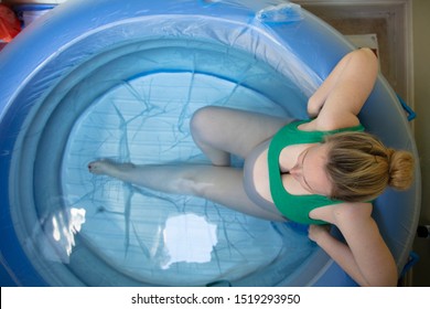 A pregnant woman in a birthing pool during a natural home birth