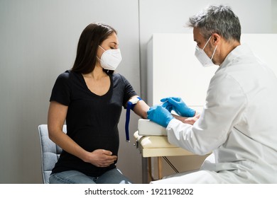 Pregnant Woman Blood Draw By Doctor In Laboratory In Face Mask