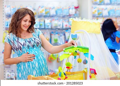 pregnant woman buying cradle with mobile toy for baby - Powered by Shutterstock