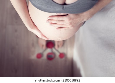 Pregnant Woman Checks Her Weight On A Scale