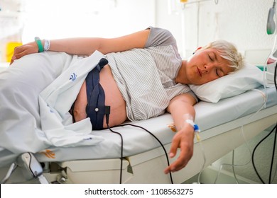 Pregnant woman with ctg belt recording the fetal heartbeat and the uterine contractions